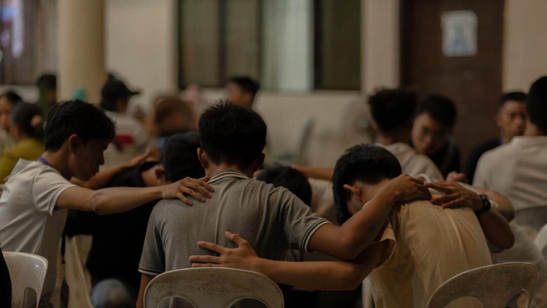 A group of people sitting around each other